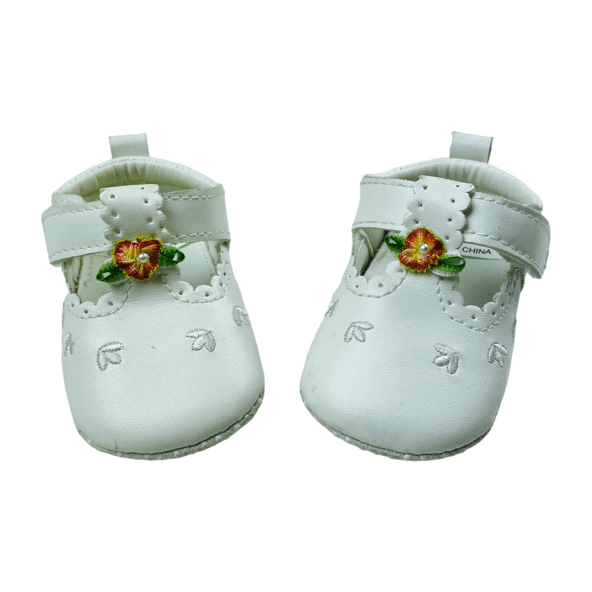 Zapatitos blandos blancos con flores en su caja